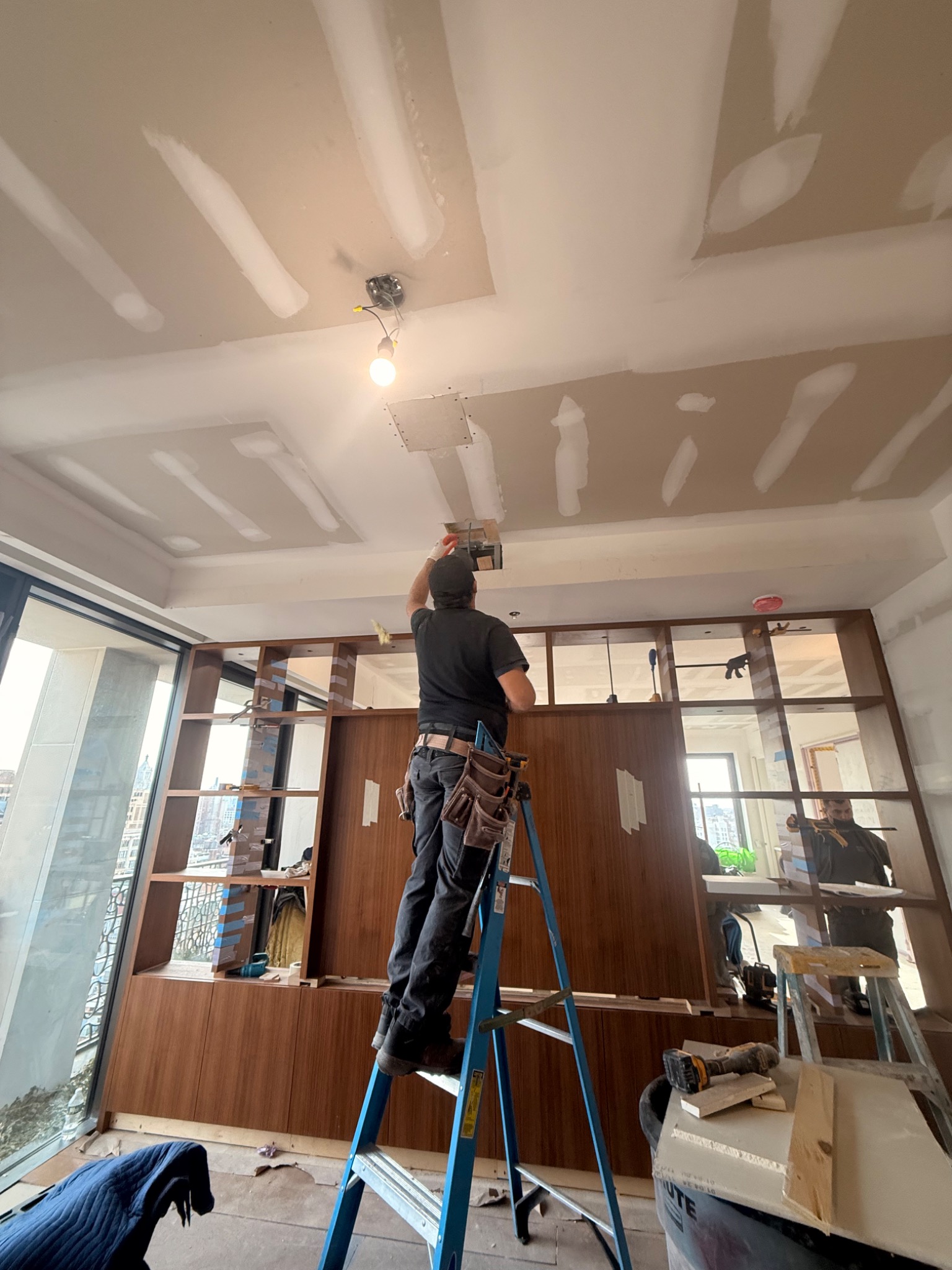 Living area under construction with unfinished ceiling and custom millwork