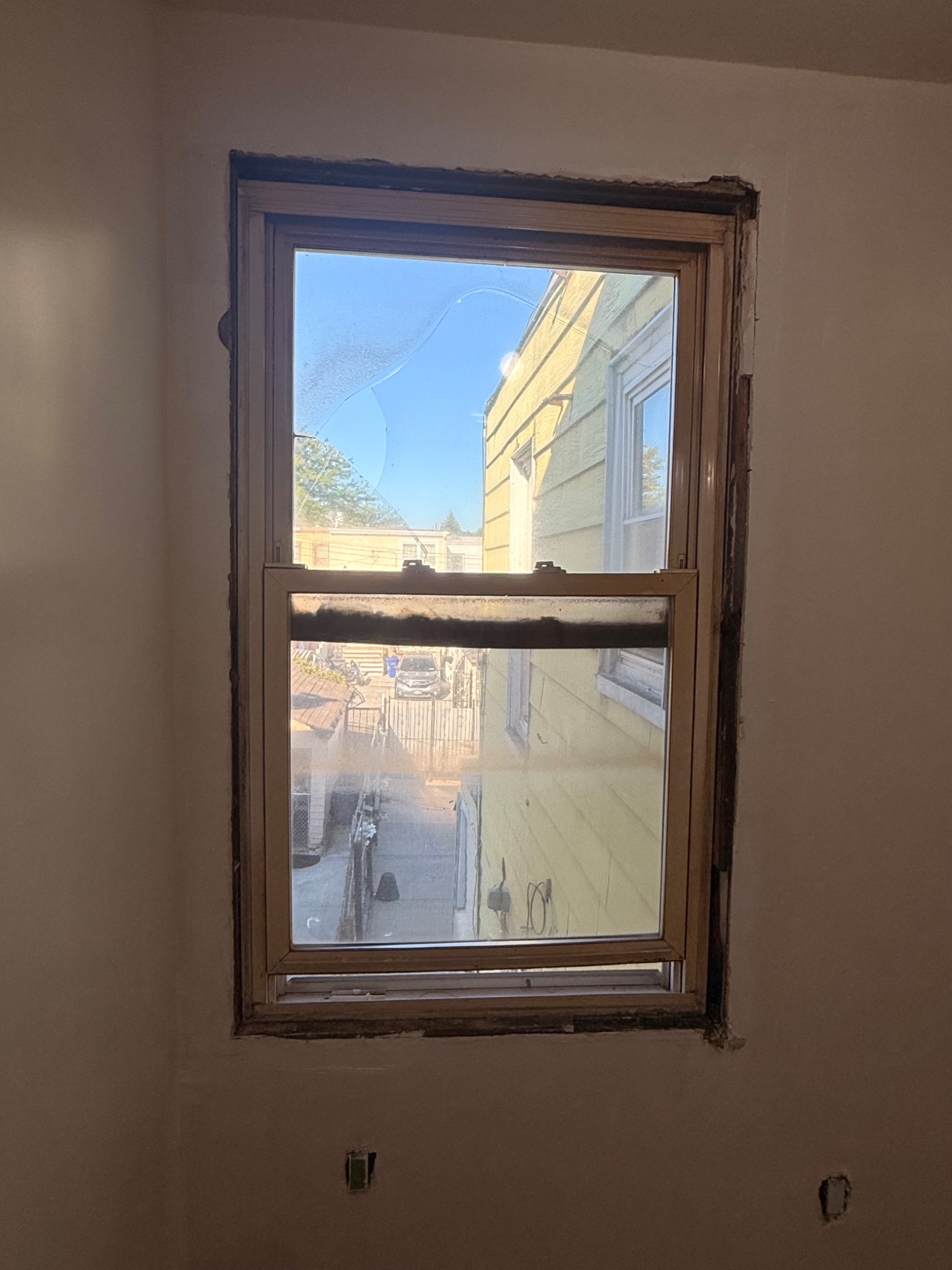 Damaged apartment window before replacement